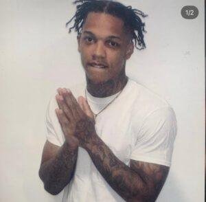 Jamonte Dandridge wearing a white T-shirt with his hands together